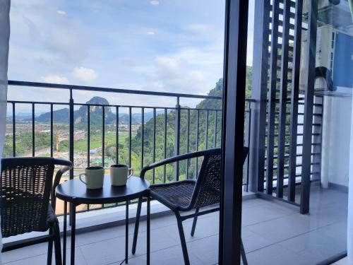 einen Tisch und Stühle auf einem Balkon mit Aussicht in der Unterkunft Sunway Onsen Studio @ Lost World of Tambun in Ipoh