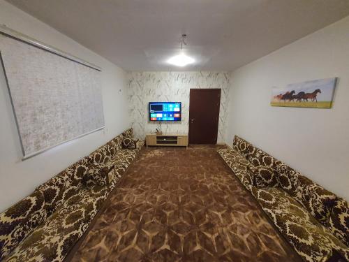 a living room with a couch and a tv in it at فيلا الراحة in Al Qunfudhah