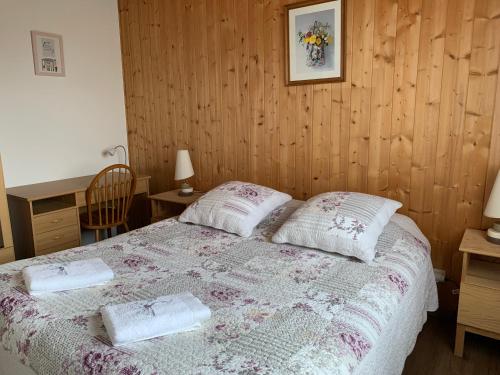 a bedroom with a bed with two pillows on it at Havre de paix - chambres dhotes in Bellegarde-sur-Valserine