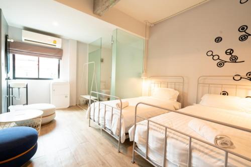 two beds in a room with a mirror at Bedspread Hostel in Bangkok
