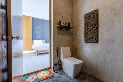 a bathroom with a toilet and a bedroom at Modern Tropical 4 Bedroom Pool Villa KH-B5 in Khao Tao