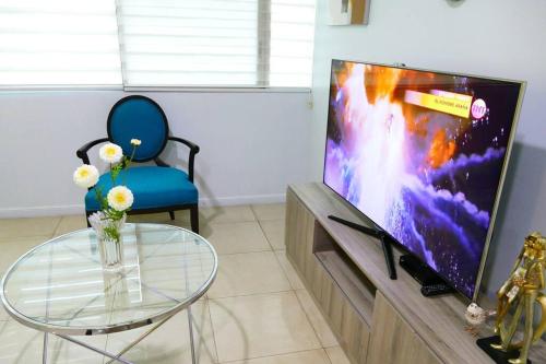sala de estar con mesa de cristal y TV en Departamento Familiar Riverfront, en Guayaquil