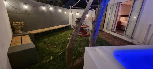 a porch swing with a bench on the side of a house at Sunshowers Plett in Plettenberg Bay