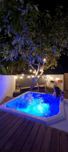 a woman sitting in a swimming pool at night at Sunshowers Plett in Plettenberg Bay