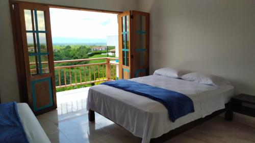 1 dormitorio con 1 cama y balcón con ventana en Tarazá Casa Campestre en Montenegro