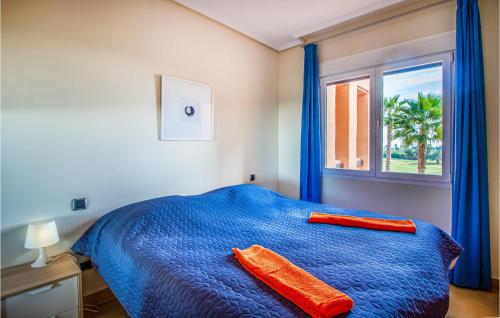 - une chambre avec un lit bleu et une fenêtre dans l'établissement Amazing Apartment In Los Alczares With Kitchen, à Los Alcázares