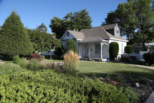 a white house with a yard with bushes at Updated Cottage 3 Bedroom Home With Game Room in River Heights
