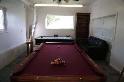 a living room with a pool table and a couch at Updated Cottage 3 Bedroom Home With Game Room in River Heights