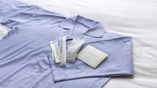 a blue shirt with a book on a bed at Toyoko Inn Nagoya Meieki Minami in Nagoya