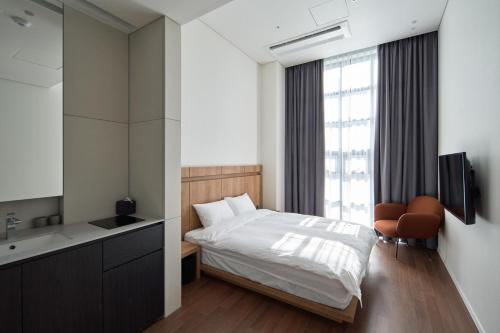 a bedroom with a bed and a sink and a mirror at Space and Mood in Busan