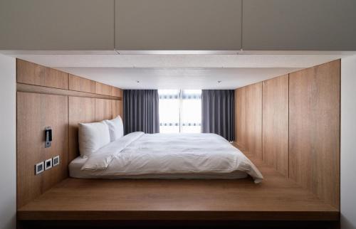 a bedroom with a large white bed with a window at Space and Mood in Busan