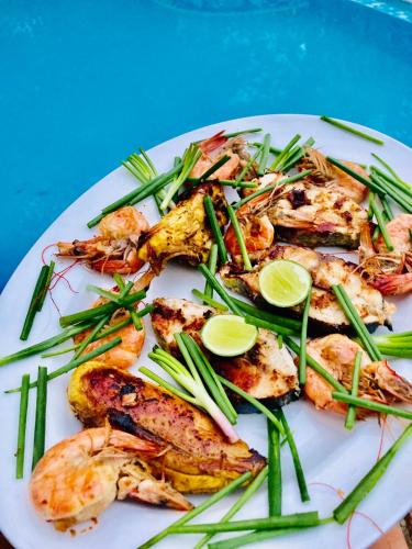 a plate of food with shrimp and green beans at Whispering House in Tangalle