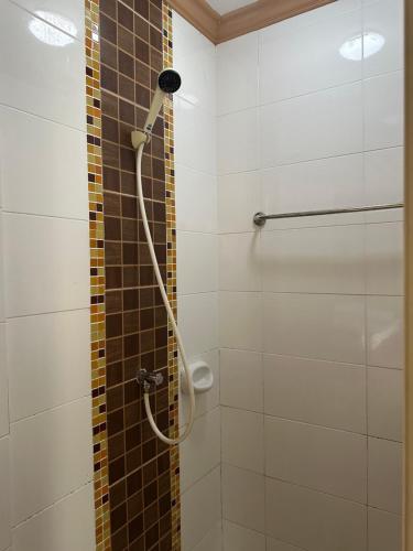 a shower with a hose in a bathroom at โรงแรมกู๊ดเรสซิเดนซ์ - Good Residence in Nong Khae