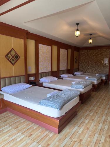 een groep van vier bedden in een kamer bij โรงแรมกู๊ดเรสซิเดนซ์ - Good Residence in Nong Khae