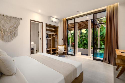 een slaapkamer met een bed en een groot raam bij Villa Maria by BaliSuperHost in Ubud