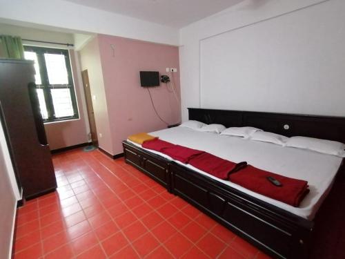 蘇丹布塔里的住宿－Tapovan Farm House，一间卧室配有一张带红色毯子的大床