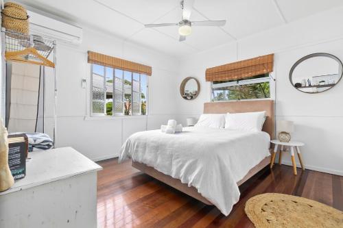 a white bedroom with a large bed and two windows at The Shack in Woorim