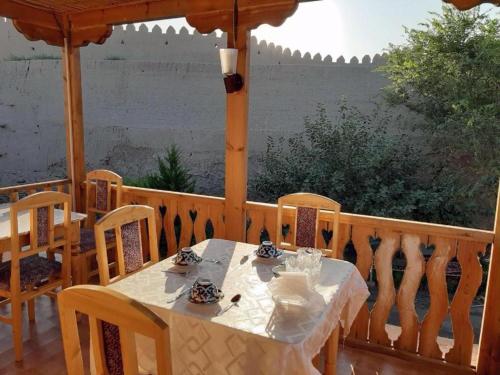 a table and chairs on a porch with a gazebo at Guest House Dilorom in Khiva