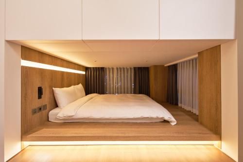 a bedroom with a bed in the middle of it at Space and Mood in Busan
