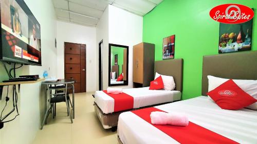 Spiral Suites Hotel في مانيلا: غرفة بسريرين ومكتب فيها