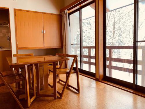 kuchnia ze stołem i krzesłami oraz oknem w obiekcie Labo Land Kurohime w mieście Shinano