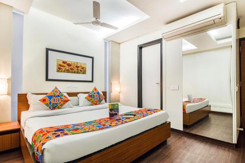 a bedroom with a bed and a mirror at FabHotel Prime Avenue in Indore