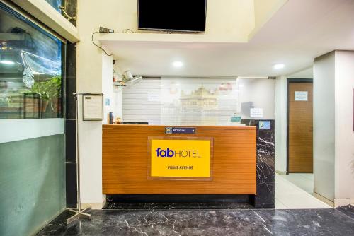 a reception desk in a building with a sign on it at FabHotel Prime Avenue in Indore