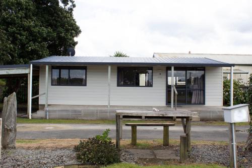 a house with a picnic table in front of it at Whanganui Seaside Holiday Park in Whanganui