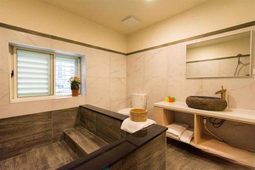 uma casa de banho com uma banheira e um lavatório em YY Elleys Home em Jiaoxi