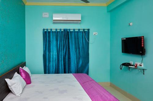 ein Schlafzimmer mit einem Bett und einem TV an der Wand in der Unterkunft deb Guest House And Banquet hall in Kalkutta