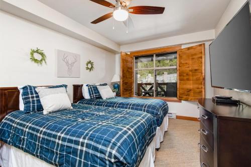 a bedroom with two beds and a flat screen tv at Powderhorn Lodge 504 Aspen View Villa in Brighton