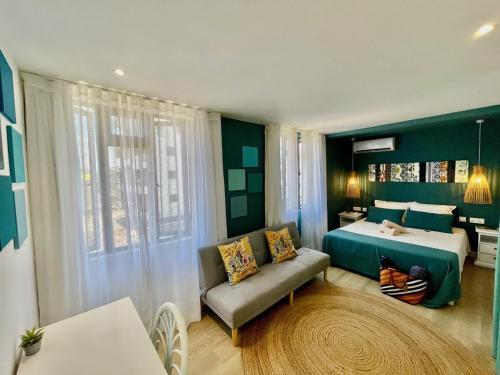 um quarto com uma cama, um sofá e uma janela em LUXURY MODERN apartment - Excellent location 50m from the beach, restaurants, bars, shops em Flic-en-Flac