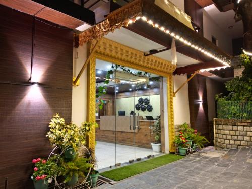 an entrance to a home with a glass door with plants at Hotel Buddha House Himalayan Brothers in Dharamshala