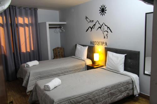 a hotel room with two beds and a sign on the wall at Lima Airport Tampu in Lima