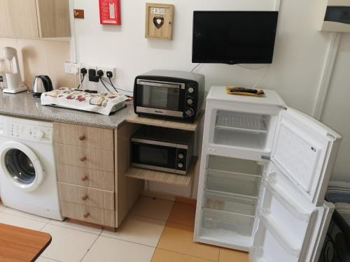 a kitchen with a microwave on a counter with a washer at Nicosia rooms Studios in Nicosia