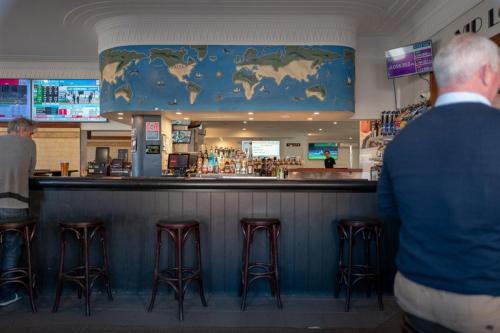 a man standing at a bar in a restaurant at Seven Seas Hotel in Carrington