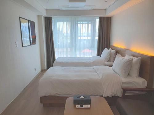 a hotel room with two beds and a window at Marinabay Sokcho in Sokcho