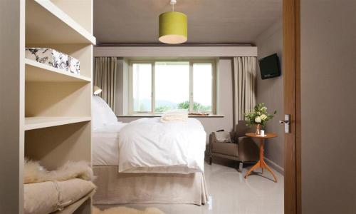 a bedroom with a white bed and a window at Harrison Stickle in Bowness-on-Windermere