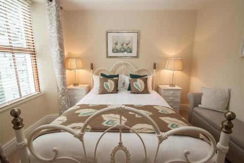 a bedroom with a bed and a chair at Acorn Cottage in Ambleside