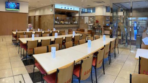 a cafeteria with rows of tables and chairs at Toyoko Inn Osaka Sakai-higashi-eki in Sakai