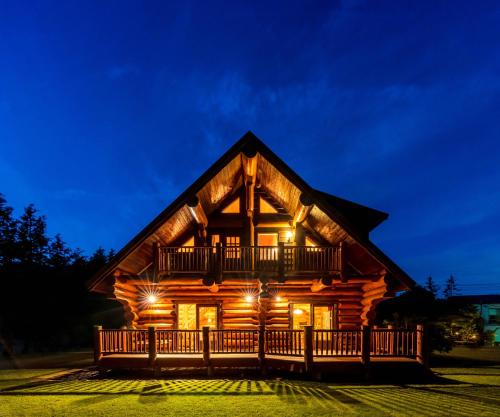 a log cabin with a deck at night at Suite Villa Hakone Sengokuhara Canadian Log in Hakone