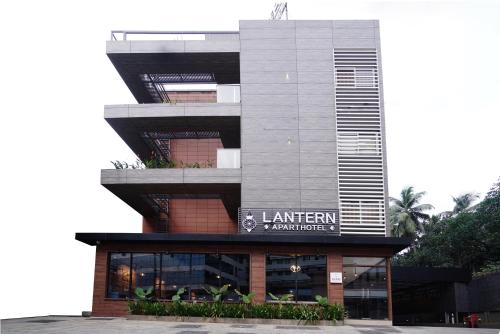 a building with a sign on the side of it at Lantern Apart Hotel in Perintalmanna