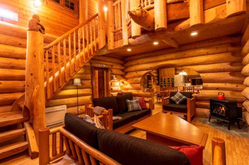 a living room with a staircase in a log cabin at Suite Villa Hakone Sengokuhara Canadian Log in Hakone