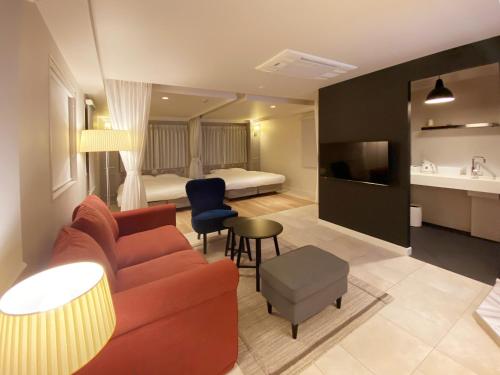 a living room with a couch and a bedroom at precious days inn in Fukuoka