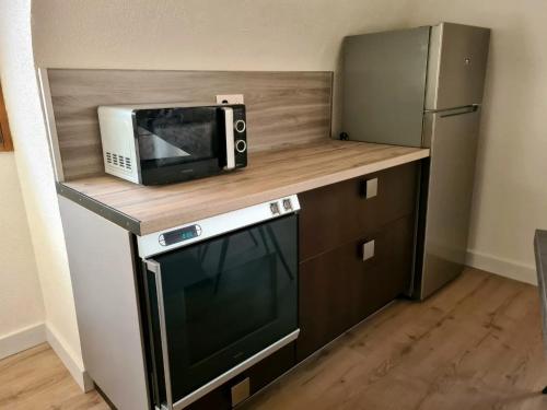 kuchenka mikrofalowa na blacie obok lodówki w obiekcie Auberge SYRA/ Proche Europa Park w mieście Marckolsheim