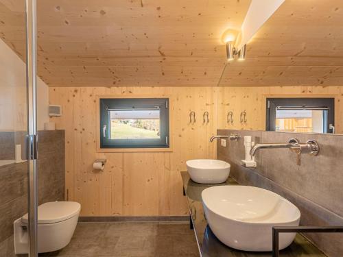 een badkamer met 2 wastafels en 2 toiletten bij Gorgeous Chalet in Steinach am Brenner near Ski Area in Steinach am Brenner