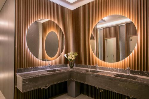 a bathroom with two sinks and two mirrors at Luxury Night Hotel in Riyadh