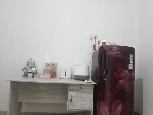 a kitchen with a counter with a refrigerator and a table at HAPDESKO HOMESTAY in Batam Center