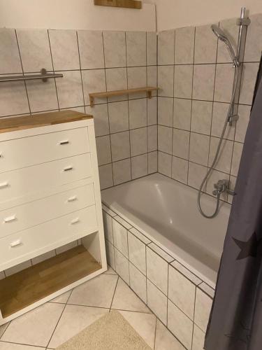 een badkamer met een wit bad en een witte kast bij B&B bei Pepe Nero. in Sankt Pölten