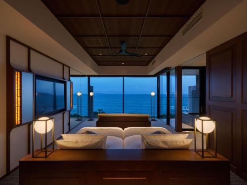a bedroom with a bed with a view of the ocean at GOTO RETREAT by Onko Chishin in Goto